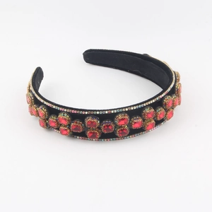 Detailed macro view of luxury black velvet headband with rows of square red crystals