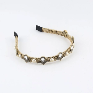 Detail of woven gold metal headband with pearls and rhinestones on white background