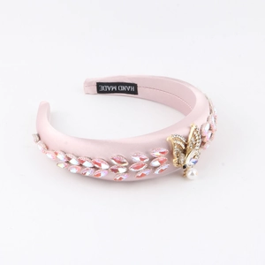 Serre-tête en satin rose rembourré avec strass irisés et détail papillon doré avec perle