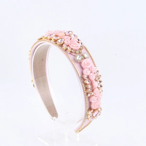 Détail d'un serre-tête baroque rose avec fleurs en tissu faites main et strass brillants