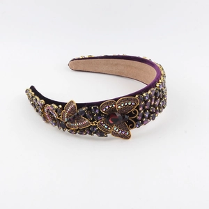 Close-up of purple velvet headband with rhinestone butterflies and crystal gemstones