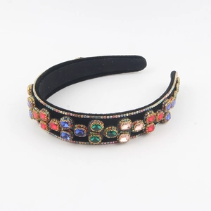 Detail of luxury black velvet headband with colorful gemstones and sparkly rhinestones