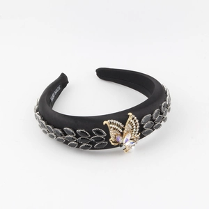 Détail d'un serre-tête fait main en satin noir avec papillon en cristal et dorures