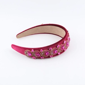 Detailed macro view of deep rose velvet headband with pink rhinestones and gold settings