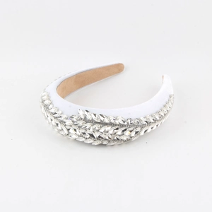 Detail showing white satin headband with marquise rhinestones in a leaf pattern