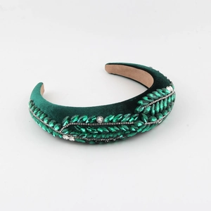 Detail of emerald green velvet headband with hand-set crystal leaves and rhinestones