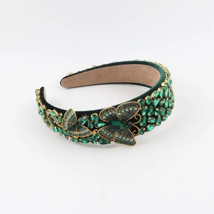 Detail of baroque velvet headband with green rhinestones and golden butterfly accents