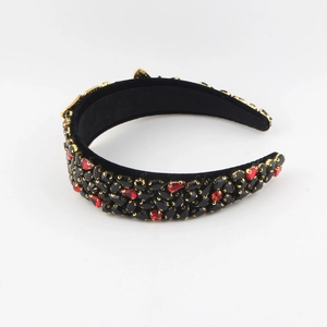 Close-up of Baroque wide headband with red and black rhinestones in golden metal claws