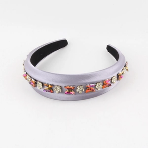 Detail of purple satin headband with rhinestone butterflies and floral accents