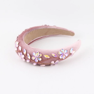 Detail of pink velvet headband featuring sparkling rhinestone flowers and golden accents