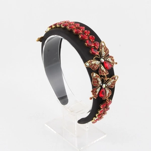Detailed view of luxury black velvet headband with golden butterflies and red crystal gems