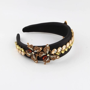 Detailed macro view of crystal butterfly ornaments on a black velvet baroque headband