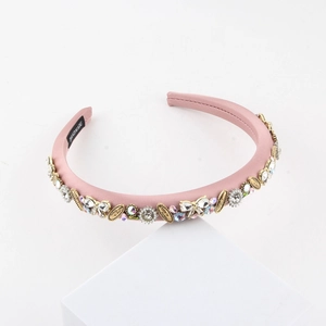 Gros plan du serre-tête en satin rose orné de cristaux et pendentif Love Is Forever