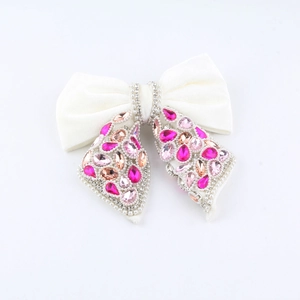 Close-up of elegant black bow hair claw clip with pink crystals and pearls detail