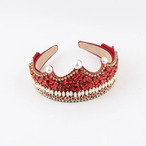 Makroansicht des kristallbesetzten Prinzessinnen-Tiaras mit roten Rubinen und Perlen