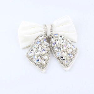 Detail view of Hepburn style black velvet bow hair claw with rhinestones and pearls