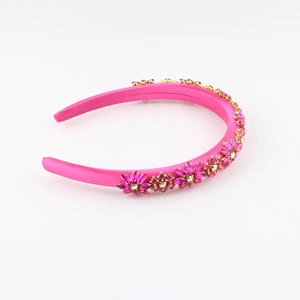Close-up of rose pink satin headband with hand-sewn crystal flowers and pearls
