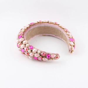 Dettaglio del cerchietto imbottito rosa con strass scintillanti e perle decorative