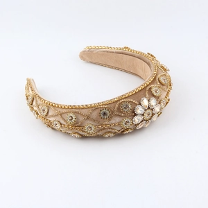 Detailed close-up of velvet headband with gold chains and sparkling crystal flower embellishments