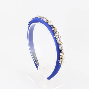 Vue détaillée du serre-tête en satin bleu avec cristaux, perles et feuilles dorées