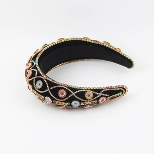 Detail showing colorful rhinestones and floral pattern on a black velvet headband