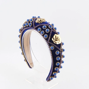 Close-up of velvet headband with golden metal roses, blue pearls and rhinestones
