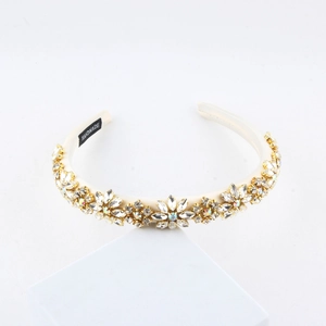 Detail of handmade baroque headband with crystals and pearls on white satin fabric
