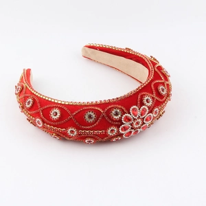 Close-up of red velvet headband with gold chains and inlaid colorful crystals