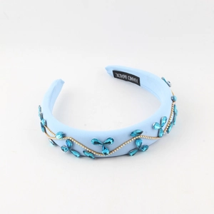 Detail of light blue fabric headband with leaf-shaped rhinestones and gold chain