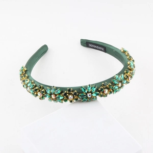 Detail of green satin headband with emerald rhinestones and handmade label