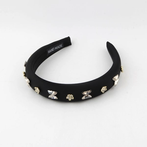 Detail of black padded headband featuring crystal butterflies and floral decorations