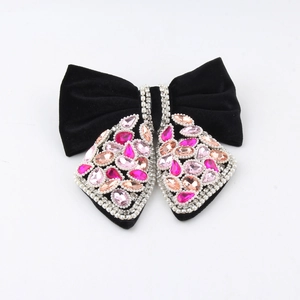 Detail of elegant black velvet hair claw with pink crystal embellishments and bow design