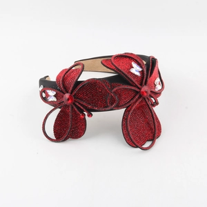 Detail of red floral headband featuring dense rhinestones and crystal flower embellishment