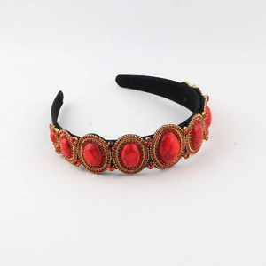 Macro shot of Baroque style headband with red gemstones and gold metallic framing details