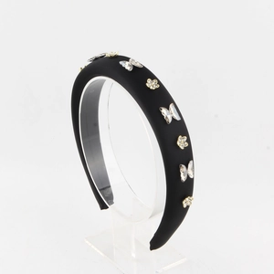 Detail of black padded headband with sparkling crystal butterflies and golden rhinestones