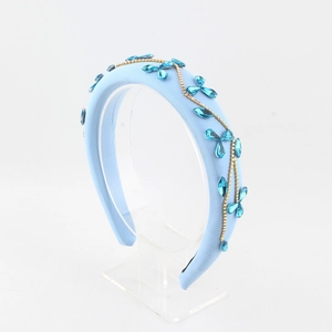 Detail of light blue sponge headband with petal-shaped blue crystals and gold chains