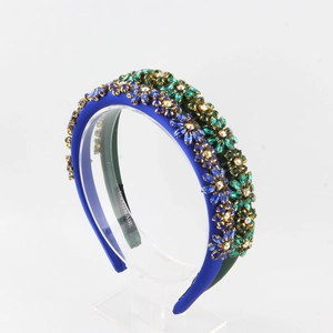 Close-up of royal blue and dark green baroque headbands with crystal flower embellishments