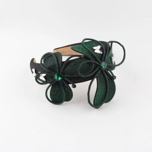 Detail view of the elegant black headband with green rhinestone flowers and crystals