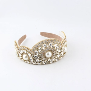 Detail of luxury rhinestone headband with white pearls on a gold metal frame
