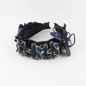 Detailed view of the velvet headband featuring crystal rhinestones and blue butterfly motifs