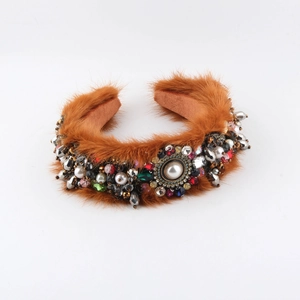 Détail d'un serre-tête en fourrure de vison avec strass colorés et perles décoratives