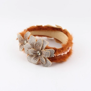 Detail view of mink fur headband featuring luxurious rhinestone flowers and tassels