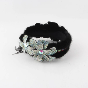 Detail of mink fur headband with rhinestone flowers and decorative metal chains
