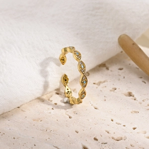 Gold open ring with geometric evil eye pattern, blue stones, and zircon inlays