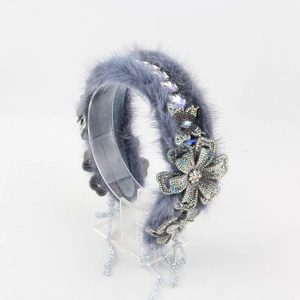 Detail van hoofdband van imitatiebont met strass-bloemen en kralenkwastjes