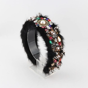 Détail d'un serre-tête luxueux en fausse fourrure avec strass colorés et perle centrale