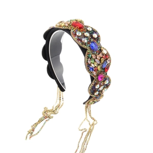 Serre-tête baroque avec strass colorés et pampilles à chaînes dorées sur fond blanc