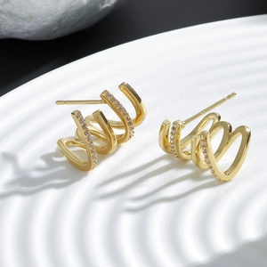 Détail de manchette d'oreille dorée avec zircon à quatre griffes et poinçon argent S925