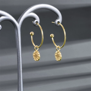 Vue détaillée d'une boucle d'oreille en C plaqué or 14K avec un pendentif gravé en étoile