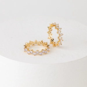 Twee 14K vergulde ringen met onregelmatige gekleurde zirkoon op een wit podium